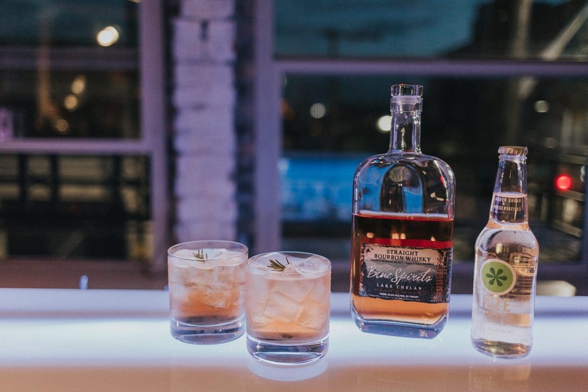whiskey rose cocktail with rye whiskey, rosemary, lemon, and sparkling apple soda